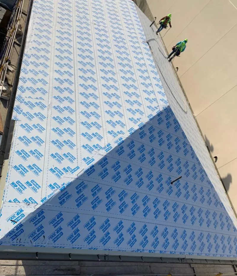 Professional roofers installing underlayment on a metal roof in Granville